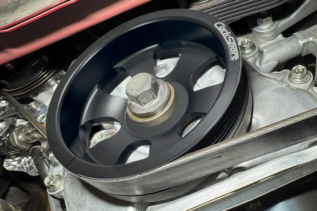 An overhead view of CorkSport's crank pulley for Mazda 3/6/CX-5/CX-9/CX-3 in the engine bay.